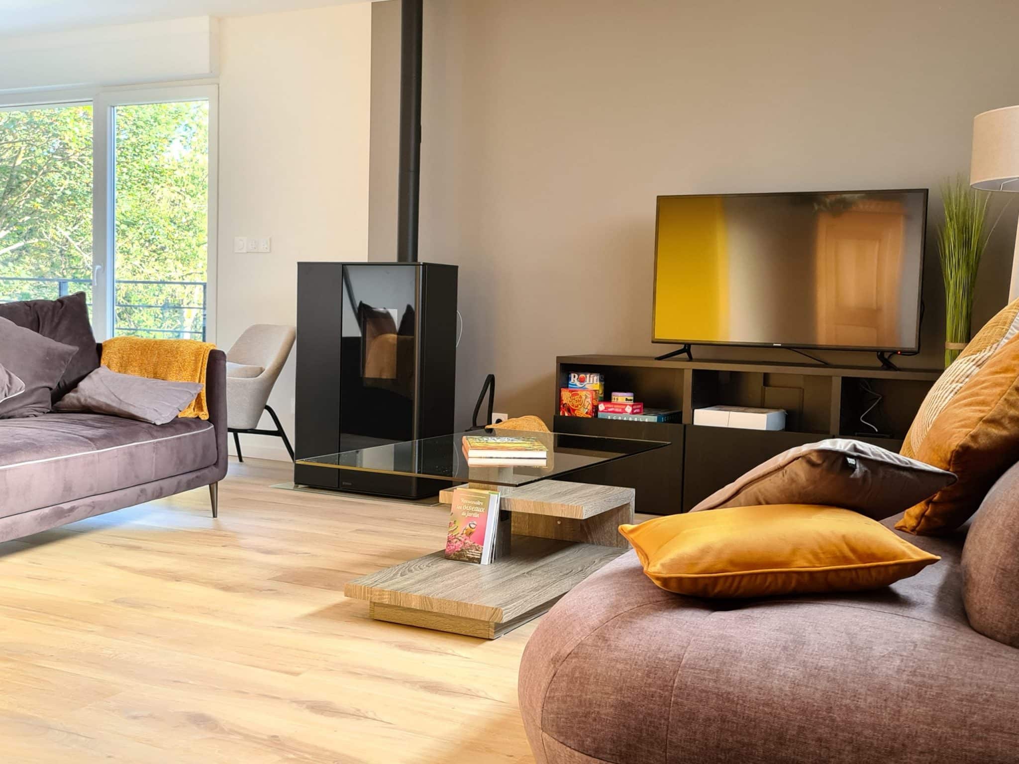 salon Salon cosy du gîte Sapin Zen avec télévision, poêle à pellets et accès à Netflix, offrant une ambiance détente et cocooning pour des soirées confortables à Goetzenbruck, dans le Pays de Bitche
